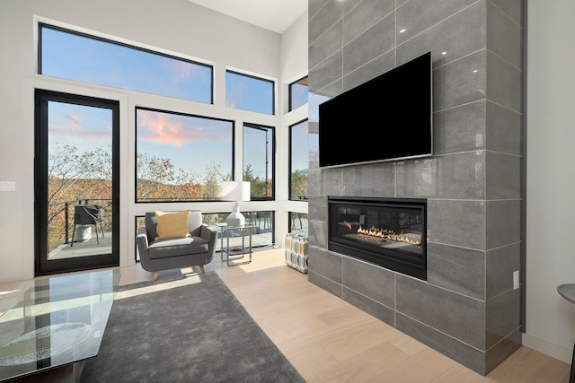 living room featuring light hardwood / wood-style floors and a tiled fireplace