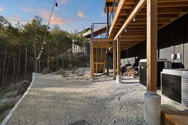 yard at dusk featuring a patio area and central air condition unit