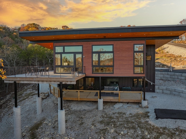 back house at dusk with a deck