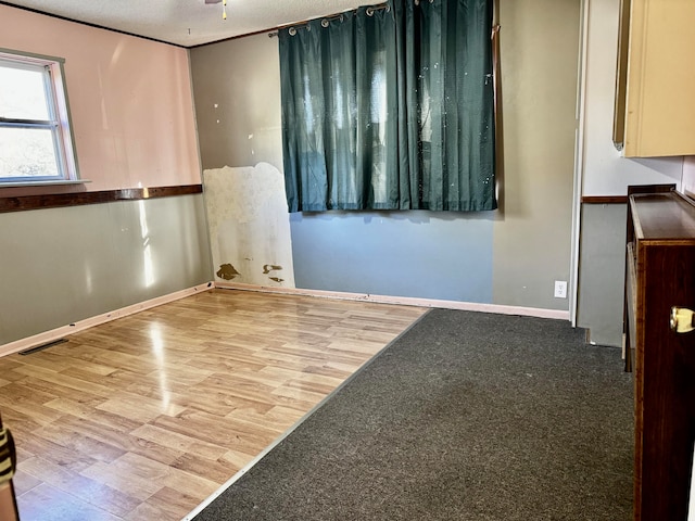 spare room with ceiling fan, light hardwood / wood-style flooring, and a textured ceiling