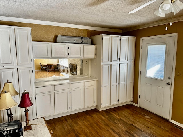 kitchen featuring dark hardwood / wood-style flooring, ornamental molding, a textured ceiling, ceiling fan, and white cabinetry