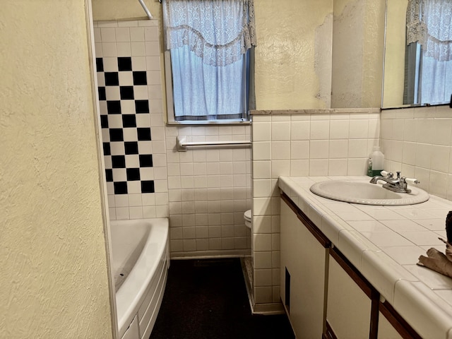 bathroom with vanity, toilet, and tile walls