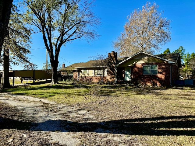 single story home with a front lawn and a carport