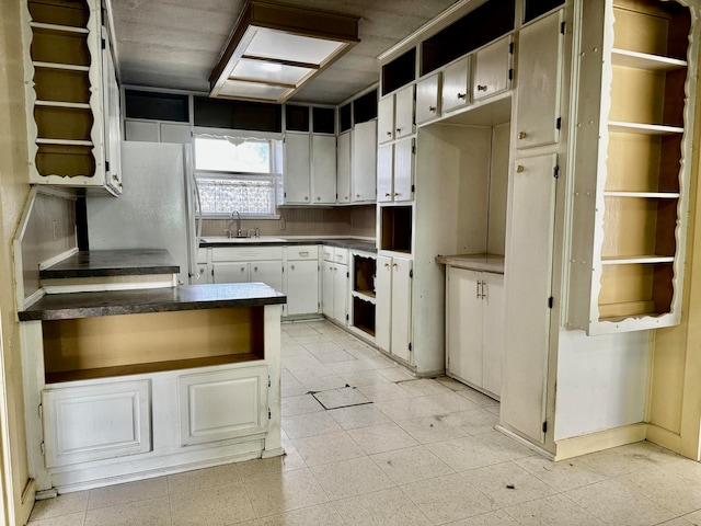 kitchen featuring white cabinets and sink