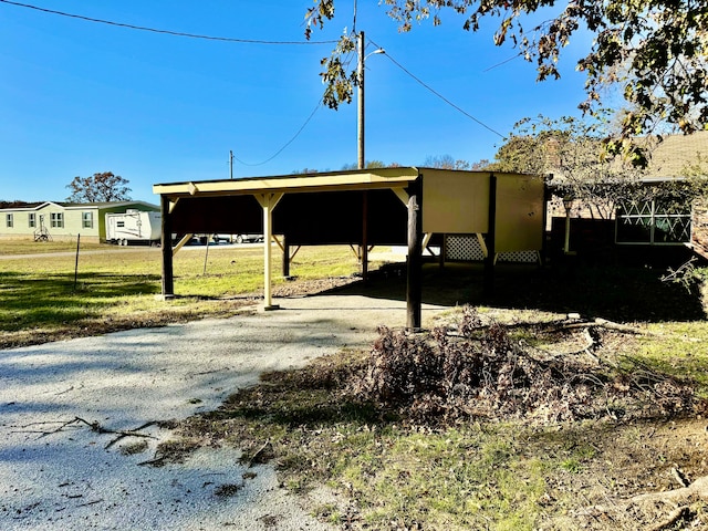 view of parking with a lawn and a carport