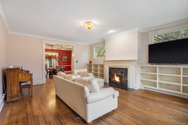 living room featuring crown molding, hardwood / wood-style floors, and a chandelier