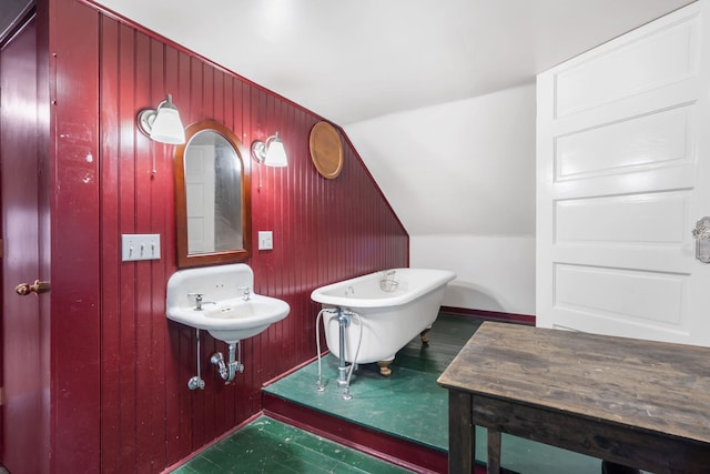 bathroom featuring a washtub and vaulted ceiling