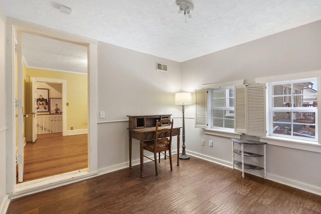 office space featuring a textured ceiling, dark hardwood / wood-style floors, and ornamental molding