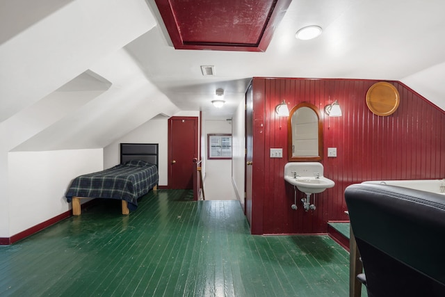 bedroom with connected bathroom, sink, dark wood-type flooring, and lofted ceiling