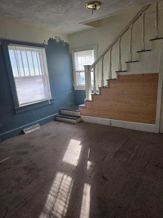 empty room with a textured ceiling and carpet floors