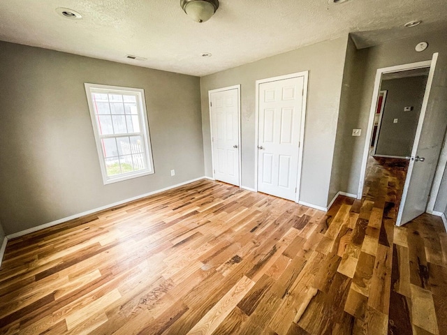 unfurnished bedroom with a textured ceiling and hardwood / wood-style flooring