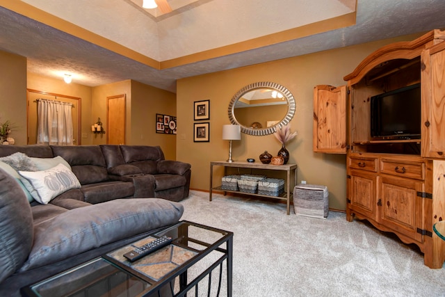 carpeted living room with ceiling fan and a textured ceiling