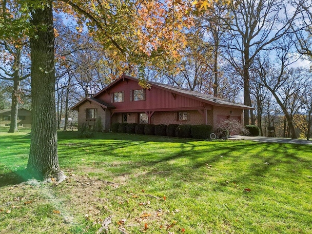 2112 Cambridge Dr, West Plains, MO 65775 - view of side of home featuring a yard, a garage, and brick siding