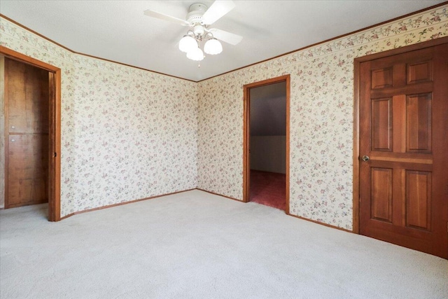 2112 Cambridge Dr, West Plains, MO 65775 - unfurnished bedroom featuring crown molding, carpet flooring, wallpapered walls, a closet, and ceiling fan