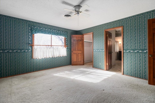 2112 Cambridge Dr, West Plains, MO 65775 - unfurnished bedroom featuring a textured ceiling, carpet, wallpapered walls, and a ceiling fan