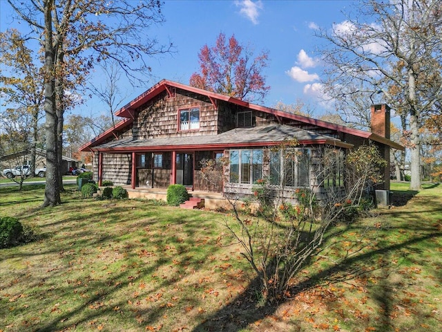 2112 Cambridge Dr, West Plains, MO 65775 - back of property with a chimney, a lawn, and a sunroom