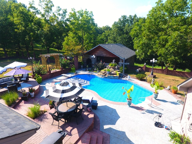 view of swimming pool featuring a patio area and an outdoor structure