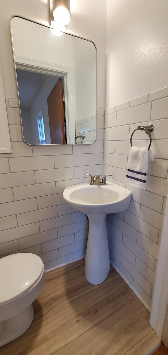 bathroom featuring toilet, tile walls, and hardwood / wood-style flooring