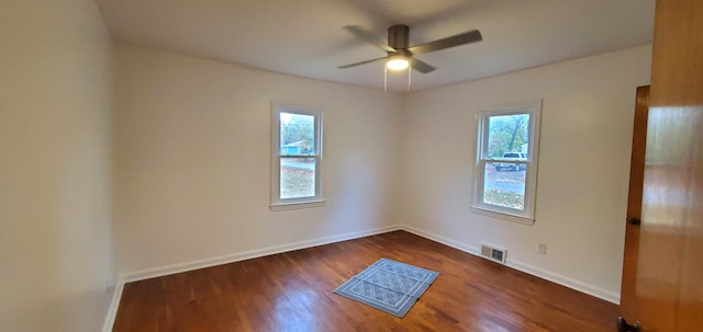 empty room with dark hardwood / wood-style floors, ceiling fan, and a healthy amount of sunlight