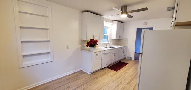 kitchen featuring white cabinetry, sink, white appliances, and light wood-type flooring