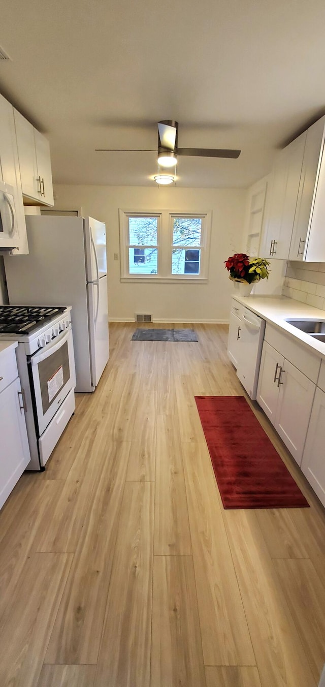 kitchen featuring white cabinetry, white appliances, and light wood-type flooring