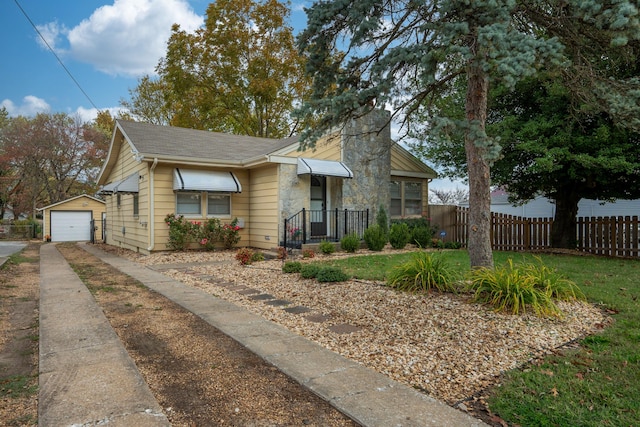 bungalow-style home with a garage and an outdoor structure