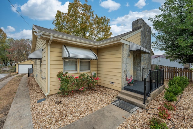 view of front of property featuring a garage and an outdoor structure