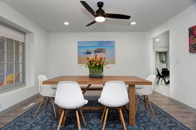 dining room with ceiling fan and dark wood-type flooring