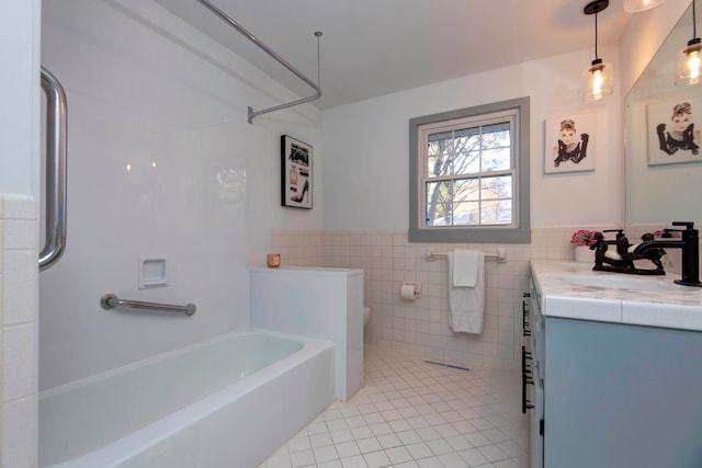 bathroom featuring tile patterned floors, vanity, tile walls, and toilet