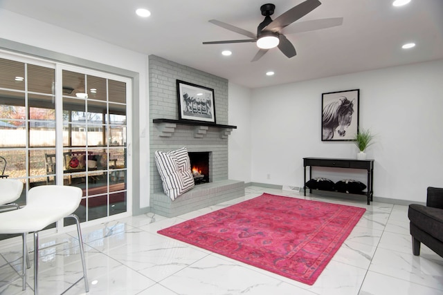 living room featuring ceiling fan and a fireplace