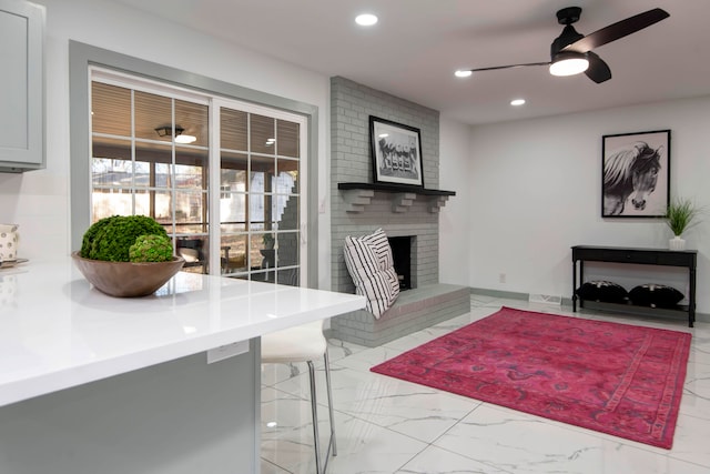 living room with ceiling fan and a fireplace