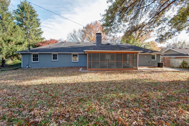 back of property with a yard, central air condition unit, and a sunroom