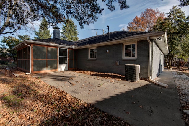 rear view of property with a sunroom, a patio area, and central air condition unit