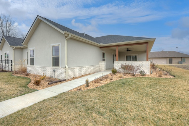 ranch-style home featuring ceiling fan and a front lawn