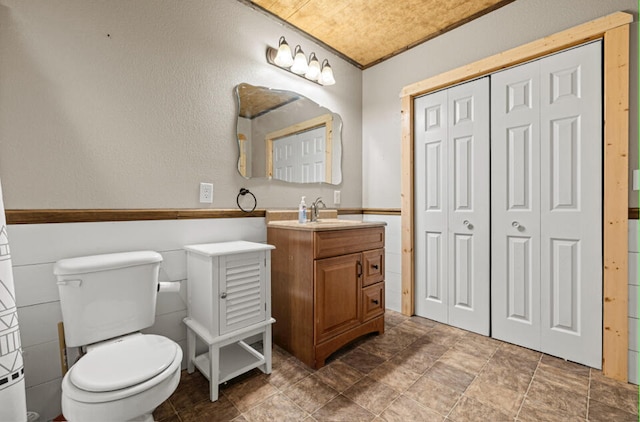 bathroom with vanity, toilet, and crown molding