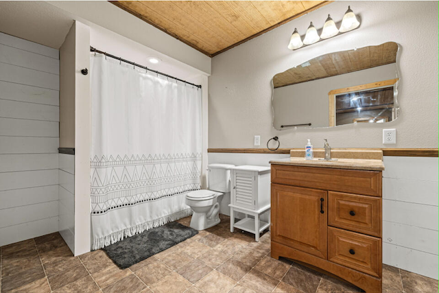 bathroom featuring vanity, wood walls, toilet, and wooden ceiling