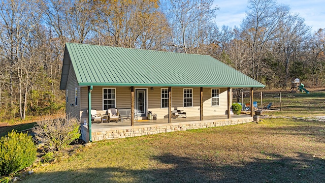 back of property featuring a yard, a patio, and a playground