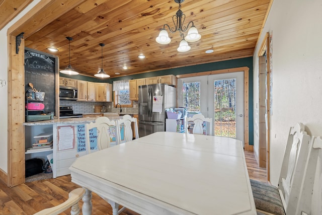 dining area with a chandelier, wood ceiling, and light hardwood / wood-style flooring