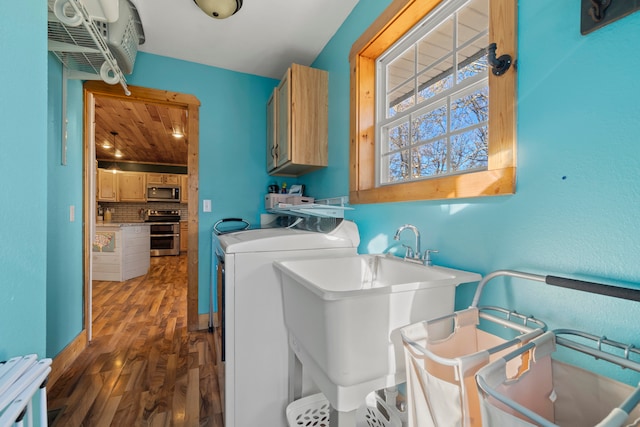 clothes washing area with cabinets, independent washer and dryer, dark hardwood / wood-style floors, and sink