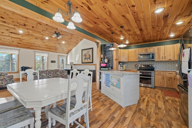 kitchen with light brown cabinets, backsplash, hanging light fixtures, light hardwood / wood-style flooring, and appliances with stainless steel finishes