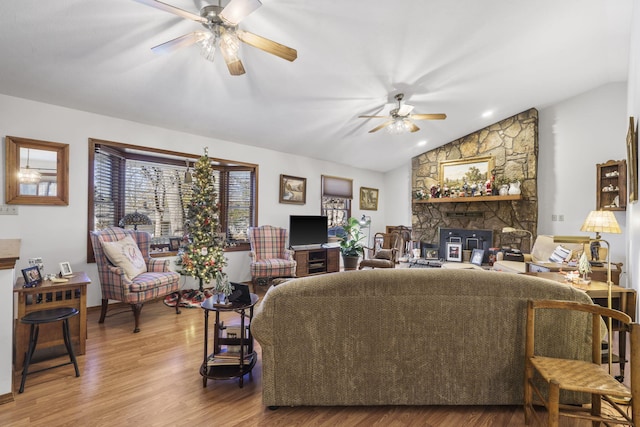 living room with hardwood / wood-style floors, ceiling fan, and vaulted ceiling