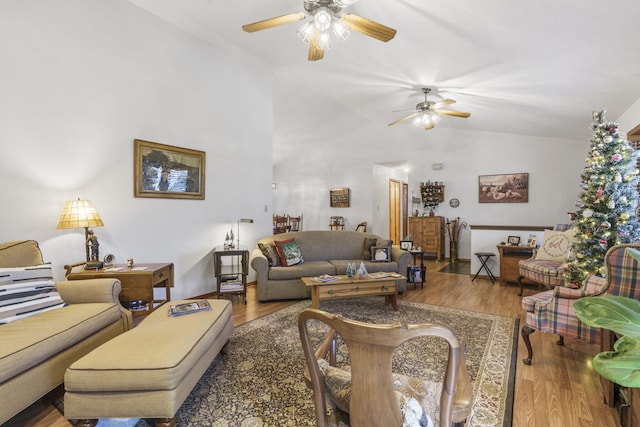 living room with ceiling fan, wood-type flooring, and lofted ceiling