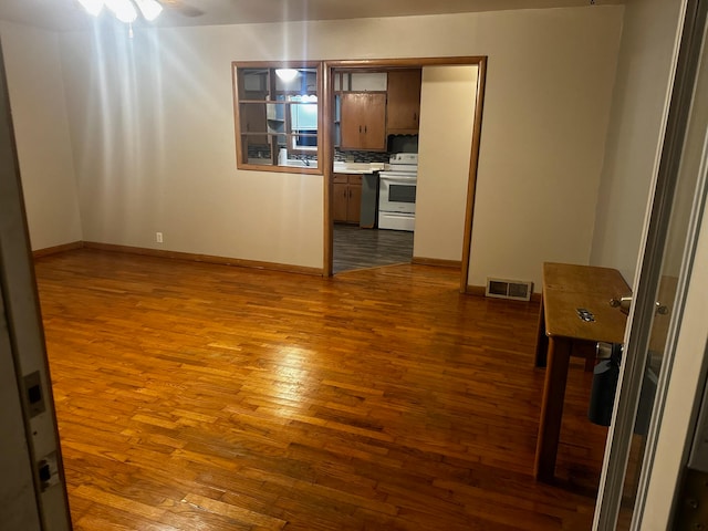 unfurnished living room featuring ceiling fan and hardwood / wood-style floors