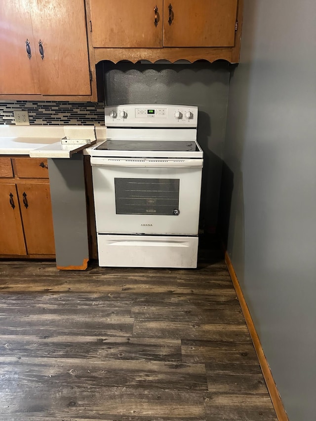 kitchen featuring white range with electric stovetop, dark hardwood / wood-style floors, and decorative backsplash