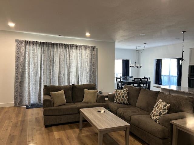 living room with light hardwood / wood-style flooring and an inviting chandelier