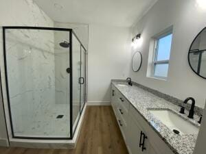 bathroom featuring a shower with door, vanity, and wood-type flooring