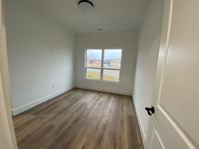 unfurnished room with dark wood-type flooring