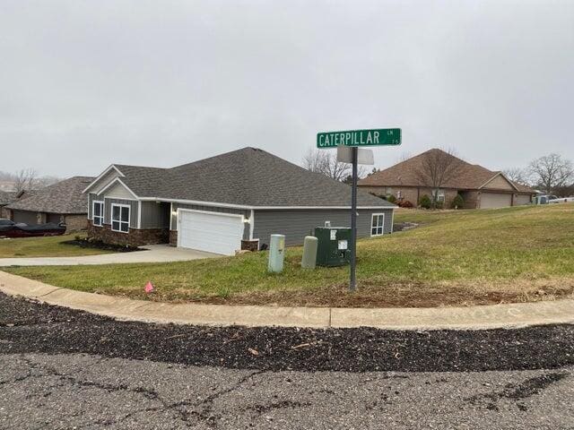 view of front of home featuring a front yard and a garage