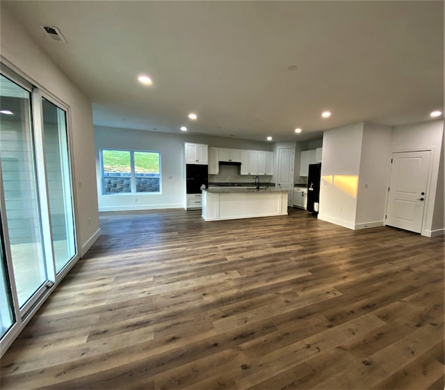 unfurnished living room with dark hardwood / wood-style flooring and sink