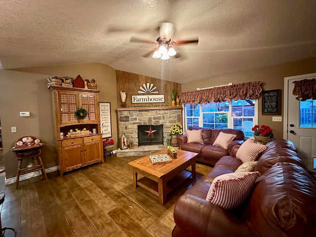 living room featuring ceiling fan, dark hardwood / wood-style floors, a textured ceiling, lofted ceiling, and a fireplace